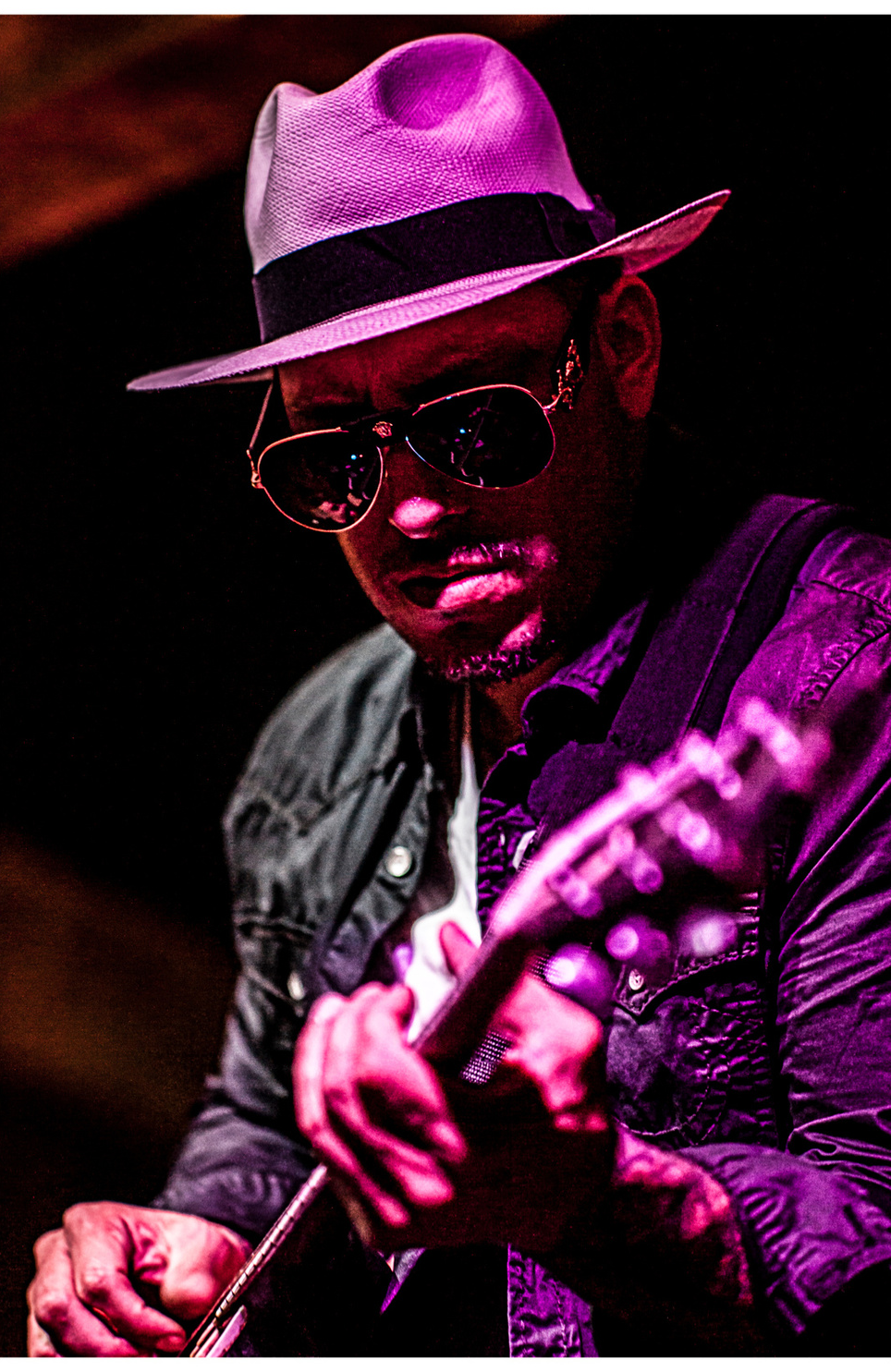 Maxx Cabello Jr. performing guitar under stage lighting